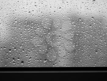Dramatic rain drops of water on the window glass background