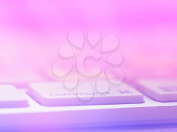 Pink and purple keyboard with command key bokeh background