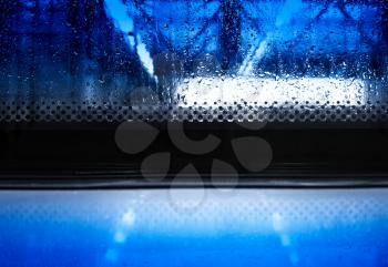 Blue fresh rain drops on window glass background