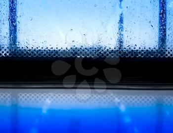 Blue fresh rain drops on window glass backdrop