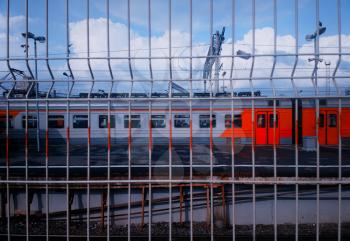 Russian railway train through jail fence background