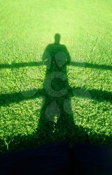 Silhouette of the man on summer green lawn background