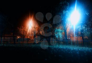 Two night lamps on city playground background