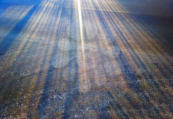 Multiple sun rays on winter road texture background