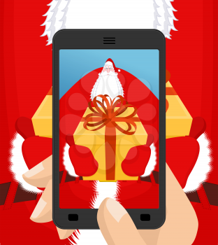 Photo Santa Claus to give gift. Christmas  Photographing smartphone. Santas gloves and box with bow. Illustration for new year. Xmas template design
