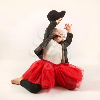 Little girl with black hat sitting and playing