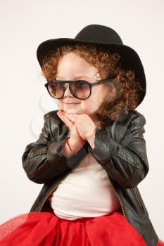 Little girl with black hat and Sunglasses sitting and smiling