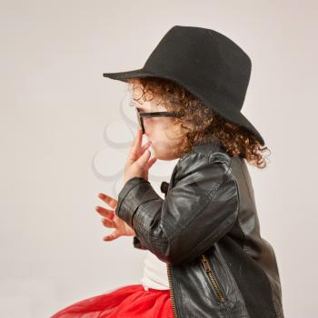 Little girl with black hat and sunglasses back view