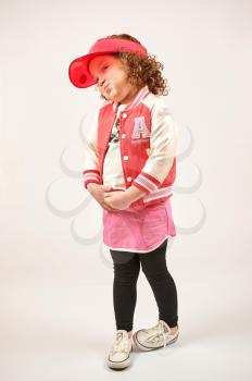 Little girl with red cap standing and smiling
