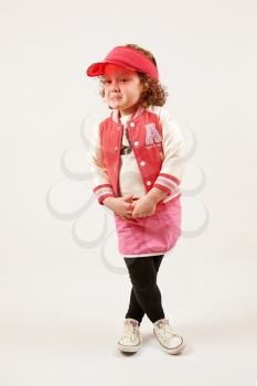 Little girl with red cap standing and smiling