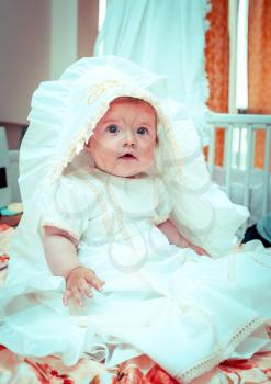 Little Baby Girl wearing a beautiful white dress waiting for baptism