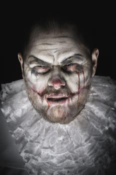 Portrait of a Scary Evil Clown.  Studio shot with horrible face art