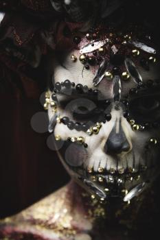 Santa Muerte Young Girl with Artistic Halloween Makeup and with Sculls in her Hair