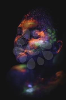 Conceptual shot of light and shine fluorescent colors young girl's face