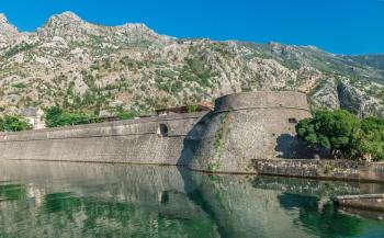 Kotor, Montenegro - 07.11.2018. Massive walls of the fortification Bastion Riva by the river Shkurda in Kotor Old Town in a sunny summer day