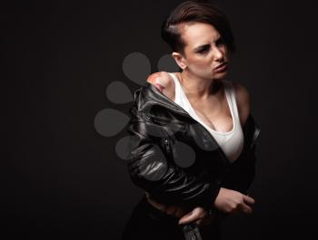 Beauty sexy woman in a leather jacket. Portrait on a dark background