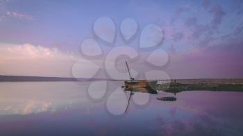 Panoramic view of the clouds above the water in a pink and purple sunset