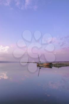 Panoramic view of the clouds above the water in a pink and purple sunset