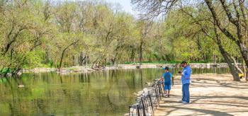 Askania-Nova, Ukraine - 04.28.2019. Tourists walk in Askania Nova Zoo, Ukraine, on a sunny spring day
