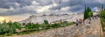 Pamukkale, Turkey – 07.14.2019. White mountain and green lake in Pamukkale. Panoramic view from the side of the village on a cloudy summer evening.