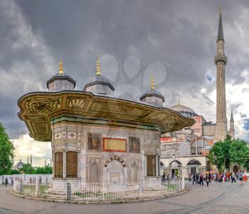 Istambul, Turkey – 07.12.2019. Fountain of Sultan Ahmet behind the gates of Topkapi in Istanbul, Turkey, on a cloudy summer day.