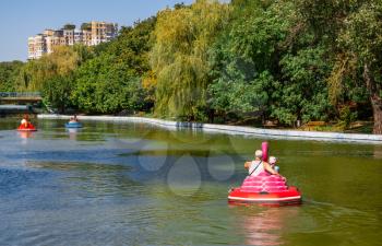 Odessa, Ukraine 08.30.2019.People ride a boat on a pond in Victory Park in Odessa, Ukraine, on a sunny autumn day