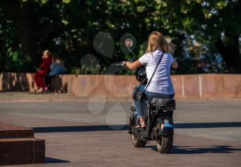 Odessa, Ukraine 09.16.2019. girl rides an electric bike in a park in Odessa, Ukraine, on a sunny autumn day