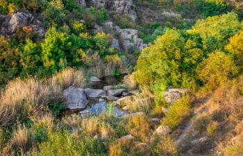 Deep granite canyon with the Mertvovod river in Aktovo village, Nikolaev region, Ukraine, on a sunny evening. One of the natural wonders of Ukraine