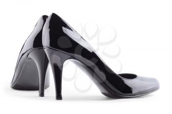 Pair of black patent leather female high-heeled shoes isolated on white background