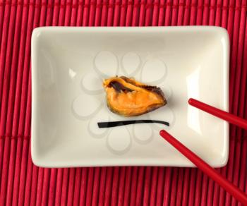 Dish with a mussel over the red bamboo mat background
