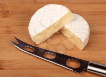 Brie cheese with a knife on the bamboo board