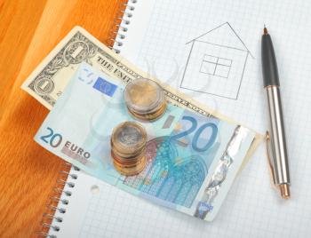 Drawn house with different currency, coins and pencil