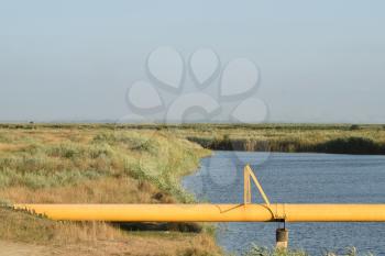 The gas pipeline through the small river. Equipment of oil and gas crafts.