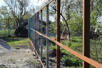 The steel frame of the new fence. The construction of the fence in the country.