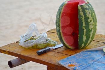 Cut watermelon with grapes on the table. Consumption of fruit on vacation.