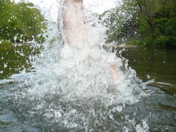 The man jumping in water. It is a lot of water splashes.