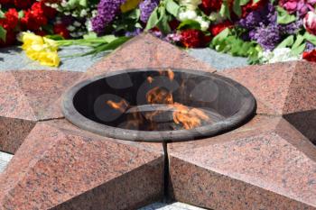 Eternal flame with flowers assigned to it. Celebration of May 9 Victory in the Great Patriotic War.