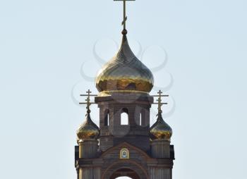 Domes of an Orthodox church. Gold-plated dome, orthodox crosses and blue roof.