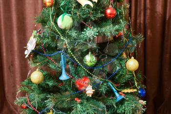 Christmas toys and ornaments on the Christmas tree. Tinsel, balls and toys decorated fir.