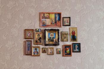 Russia, Poltavskaya village - 31 December 2015: Orthodox Christian icons on the wall, glued wallpaper.