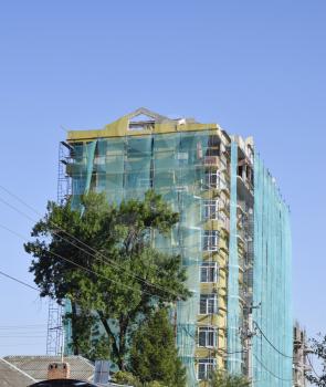Safety net in the newly built high-rise building. Green grid on building of objects falling from a height.