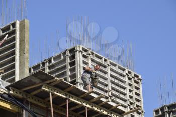 Worker pouring cement. Construction of a multistory building. Installation of the concrete walls of the building.