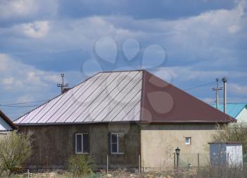 The roof of corrugated sheet on the houses. Individual homes with roof made of profiled sheet metal.
