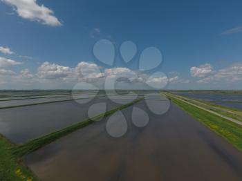 Flooded rice paddies. Agronomic methods of growing rice in the fields. Flooding the fields with water in which rice sown. View from above.