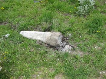 Broken concrete column. Destroyed a concrete fence on the grass.