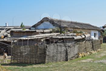 The roofs of reeds on the house and the garage. Wicker fence near ethnic Cossack home.