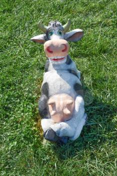 Toy cow lying upside udder. Dummies of animals.