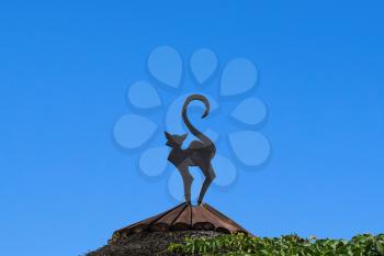 Figure of a cat on a roof. Cut out from a tree of decoration of the rooftop.