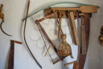 Vintage tools on the wall. Saws, ax, sickle and other vintage instruments.