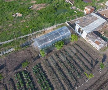 Top view of the garden with a greenhouse made of polycarbonate. Household.